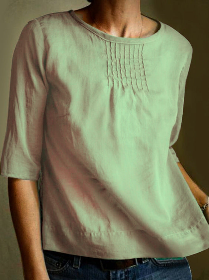 Maglietta donna in cotone verde chiaro, maniche a tre quarti, scollo rotondo, dettagli plissettati sul petto. Moda casual, abbigliamento estivo.