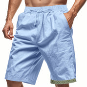 Pantaloncini uomo azzurri in cotone, con tasche laterali e bordo decorativo. Ideali per sport e tempo libero. Moda estiva casual.
