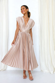 Abito lungo plissettato color champagne, scollatura a V profonda, indossato da donna sorridente. Elegante moda femminile, abbigliamento estivo.