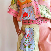 Completo estivo donna in lino colorato con motivi floreali, cintura coordinata e dettagli ricamati. Moda femminile, abbigliamento estivo elegante.