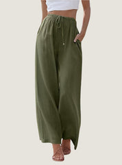 Pantaloni larghi verdi da donna, vita alta con coulisse, tessuto leggero, abbinati a top bianco corto, stile casual estivo.