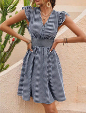 Abito estivo a righe bianche e blu, scollo a V, maniche a volant, vita arricciata. Perfetto per moda donna, look casual elegante.