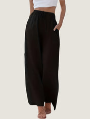 Pantaloni neri larghi da donna, vita alta con coulisse, tasche laterali, abbinati a top bianco corto. Stile casual ed elegante.