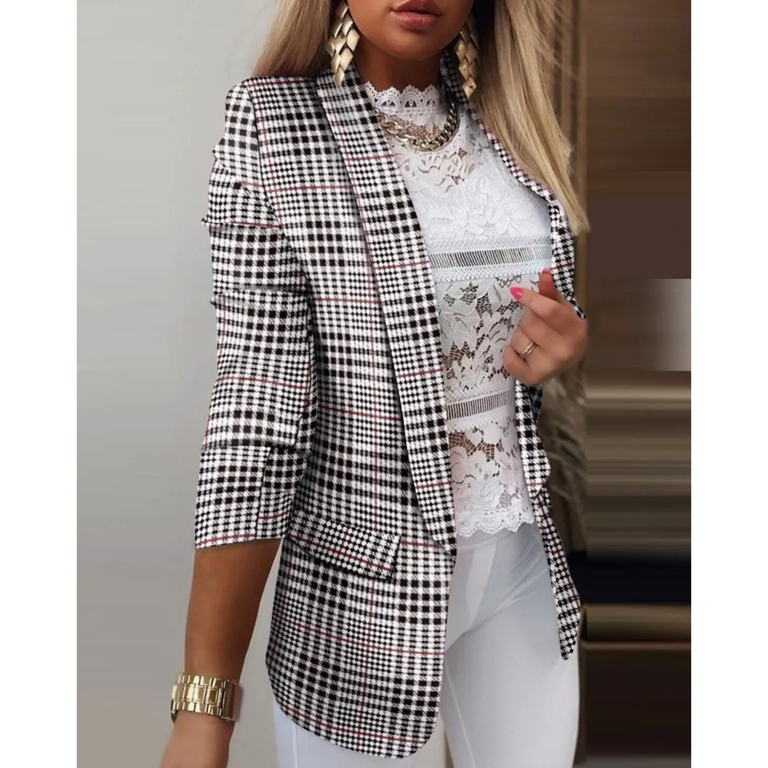 Blazer a quadri bianco e nero da donna, maniche a tre quarti, abbinato a top in pizzo bianco. Look elegante e moderno per ufficio o eventi formali.