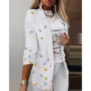 Blazer bianco da donna con farfalle colorate, maniche a tre quarti, abbinato a top in pizzo bianco. Elegante e moderno, ideale per moda primaverile.