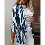 Giacca donna a righe blu e bianche, maniche a tre quarti, indossata su top in pizzo bianco. Moda elegante, abbigliamento femminile trendy.