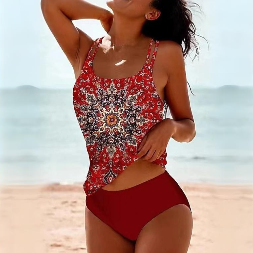 Donna in costume da bagno rosso con stampa mandala, spiaggia estiva sullo sfondo. Moda mare, abbigliamento donna, tendenze estive 2023.