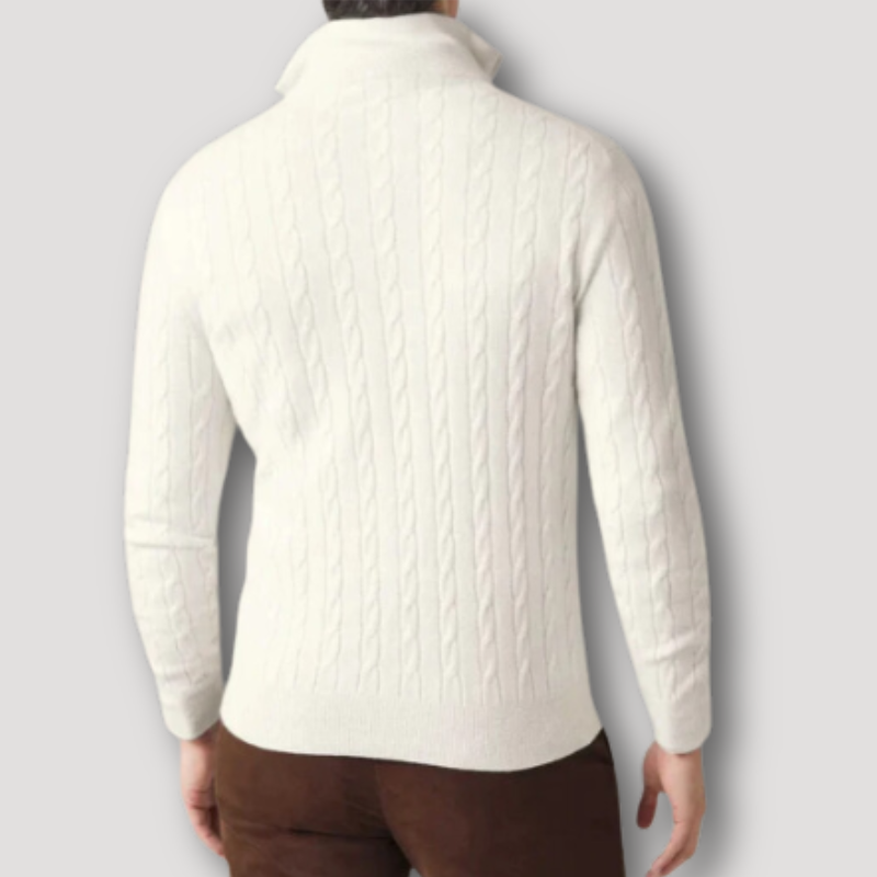 Maglione bianco a trecce da uomo, collo alto, maniche lunghe, indossato su pantaloni marroni. Elegante e caldo, ideale per l'inverno.
