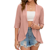 Cardigan rosa traforato da donna, maniche a tre quarti, abbinato a top bianco e shorts di jeans strappati. Look casual estivo.