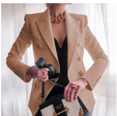 Giacca elegante beige da donna con bottoni dorati, abbinata a top nero e accessori moda. Look sofisticato e moderno per eventi formali.