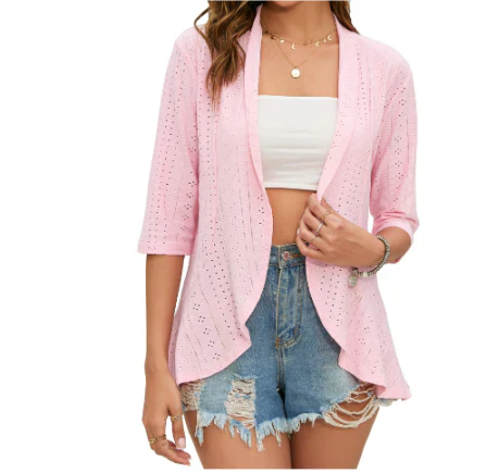 Giacca cardigan rosa traforata da donna, maniche a tre quarti, abbinata a top bianco e shorts di jeans strappati. Moda estiva casual.