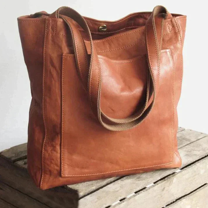 Borsa tote in pelle marrone su sfondo neutro, design elegante e spazioso, ideale per moda donna, accessori di lusso, shopping e lavoro.