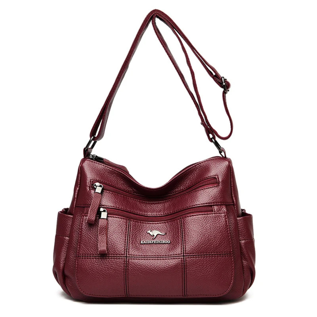 Borsa a tracolla in pelle rossa, design elegante con tasche multiple e cerniere, ideale per donna. Accessorio moda versatile e di tendenza.