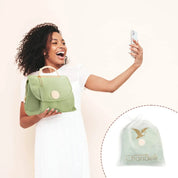 Donna sorridente con borsa verde Chandelli, scatta selfie. Borsa elegante in tessuto, perfetta per moda estiva. Include sacchetto protettivo.