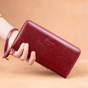 Portafoglio donna in pelle rossa, design elegante con cerniera, cinturino da polso, ideale per moda e accessori femminili.