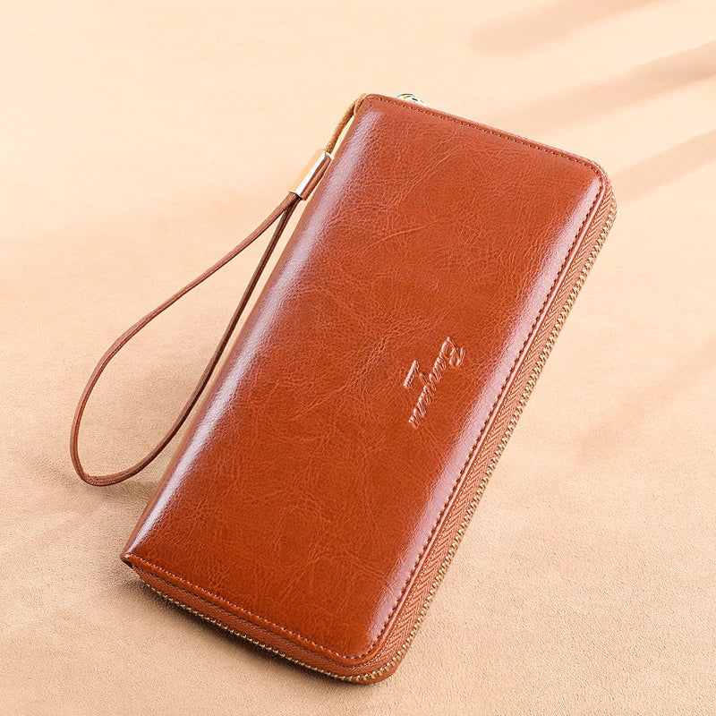 Portafoglio in pelle marrone con cerniera e cinturino da polso, design elegante e funzionale, ideale per uomo e donna, accessorio moda di qualità.