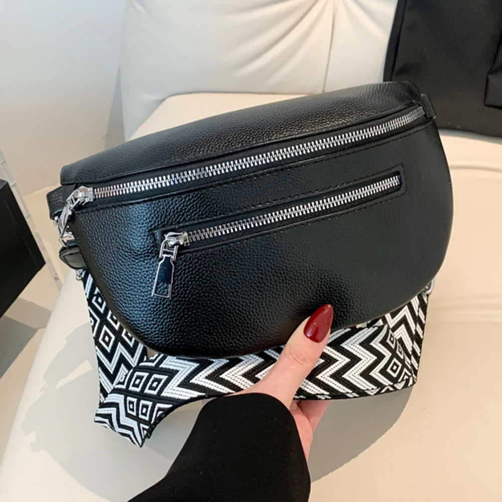 Marsupio in pelle nera con cerniere argentate e motivo geometrico bianco e nero. Accessorio moda elegante, perfetto per look casual e urbani.
