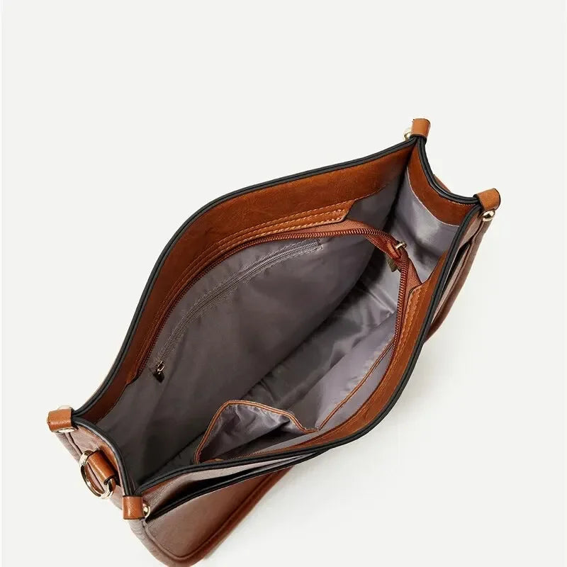 Borsa a tracolla in pelle marrone con interno foderato grigio, tasca con zip e scomparti multipli. Accessorio moda elegante e funzionale.