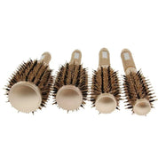 Quattro spazzole rotonde per capelli di diverse dimensioni, setole marroni, manico ergonomico beige, ideali per styling e volume.