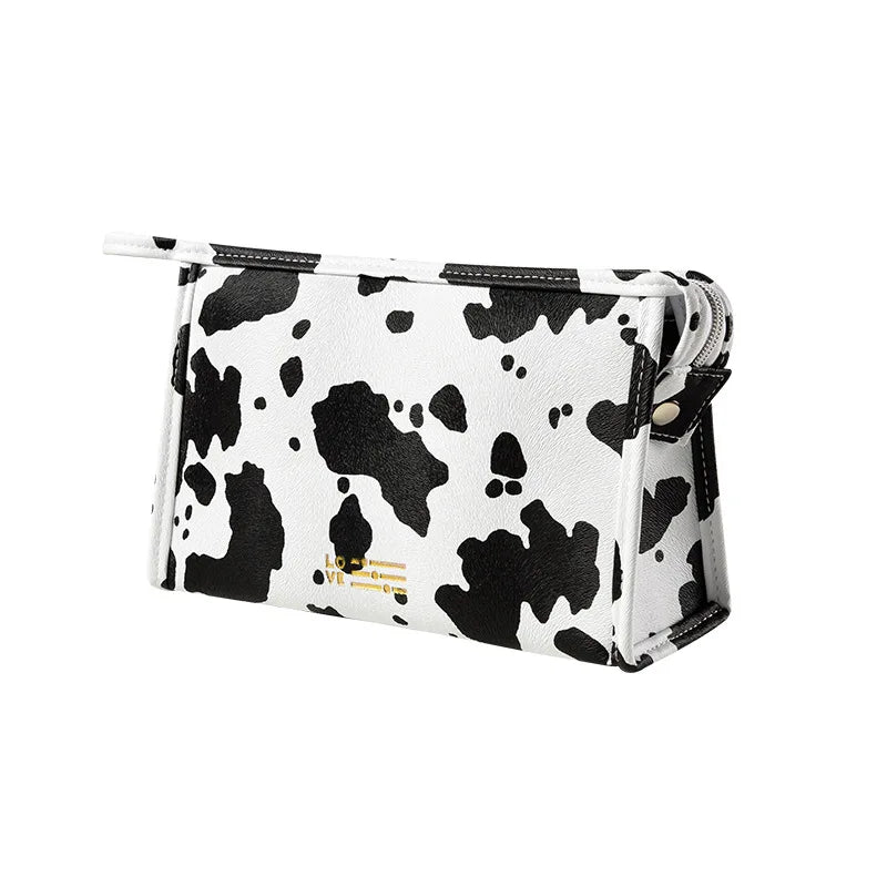 Borsa a tracolla in ecopelle bianca e nera con stampa mucca, design moderno, chiusura a zip, accessorio moda donna, stile casual chic.