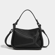 Borsa a tracolla nera in pelle con cuciture bianche, design moderno, manico superiore e tracolla regolabile. Accessorio moda elegante e versatile.