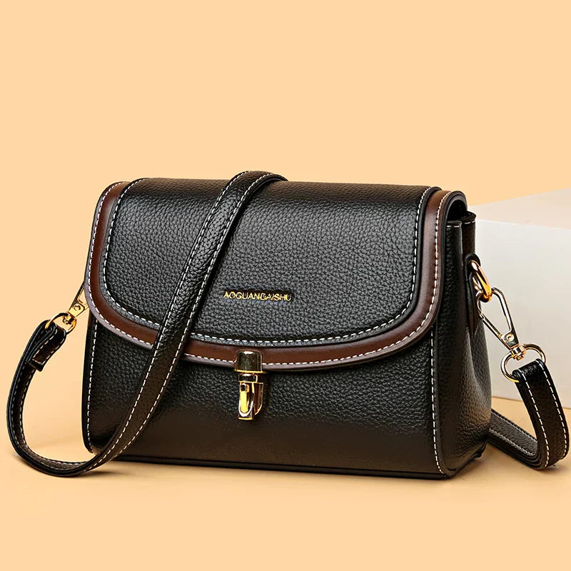 Borsa a tracolla in pelle nera con dettagli marroni, chiusura a fibbia dorata, design elegante e moderno, perfetta per moda donna e accessori.
