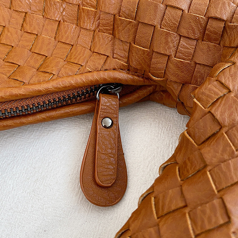 Borsa intrecciata in pelle marrone con cerniera, dettaglio chiusura. Accessorio moda elegante, artigianale, perfetto per look casual e chic.