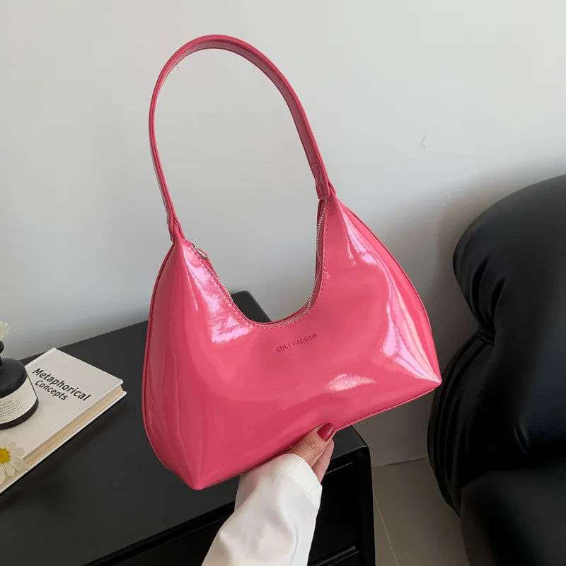 Borsa a spalla rosa lucida, design moderno, manico singolo, su sfondo neutro. Accessorio moda elegante, perfetto per look casual e chic.