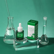 Siero viso IRÉN Skin Centella su supporto trasparente, confezione verde, beuta e cilindro graduato su sfondo verde. Skincare coreana, idratante.