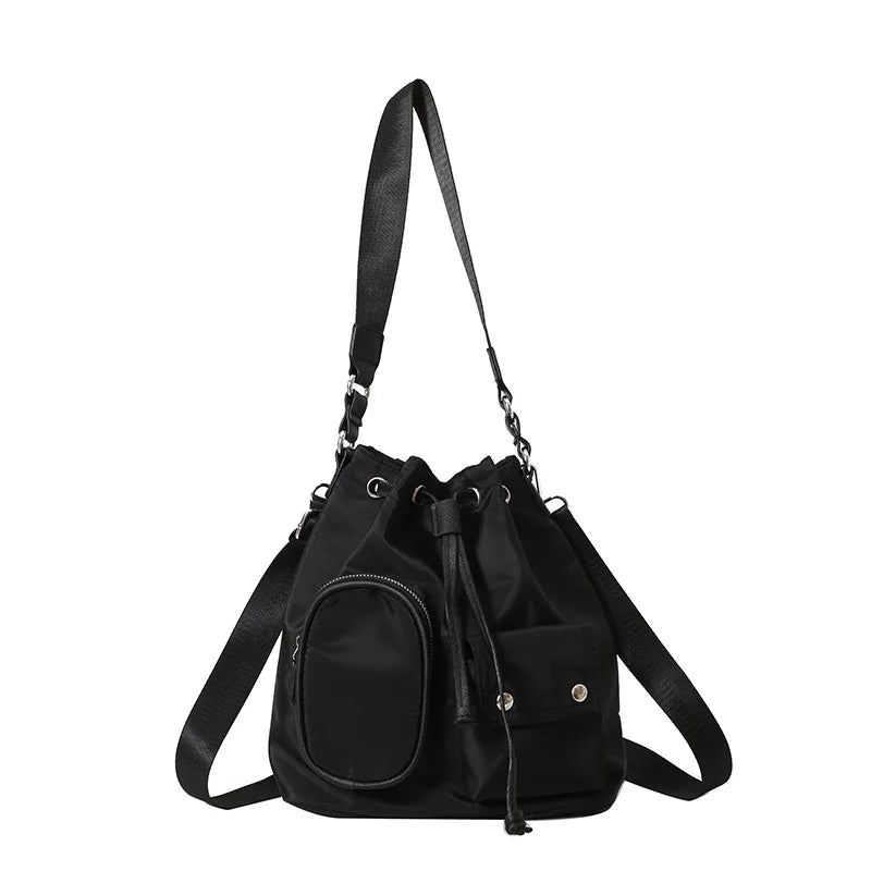 Zaino a secchiello nero in nylon con tasche multiple, chiusura a coulisse e tracolla regolabile. Design moderno e funzionale per uso quotidiano.