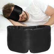 Uomo che dorme con maschera per dormire in seta nera, cuscino bianco. Mascherina notte, accessorio relax, sonno profondo, comfort.
