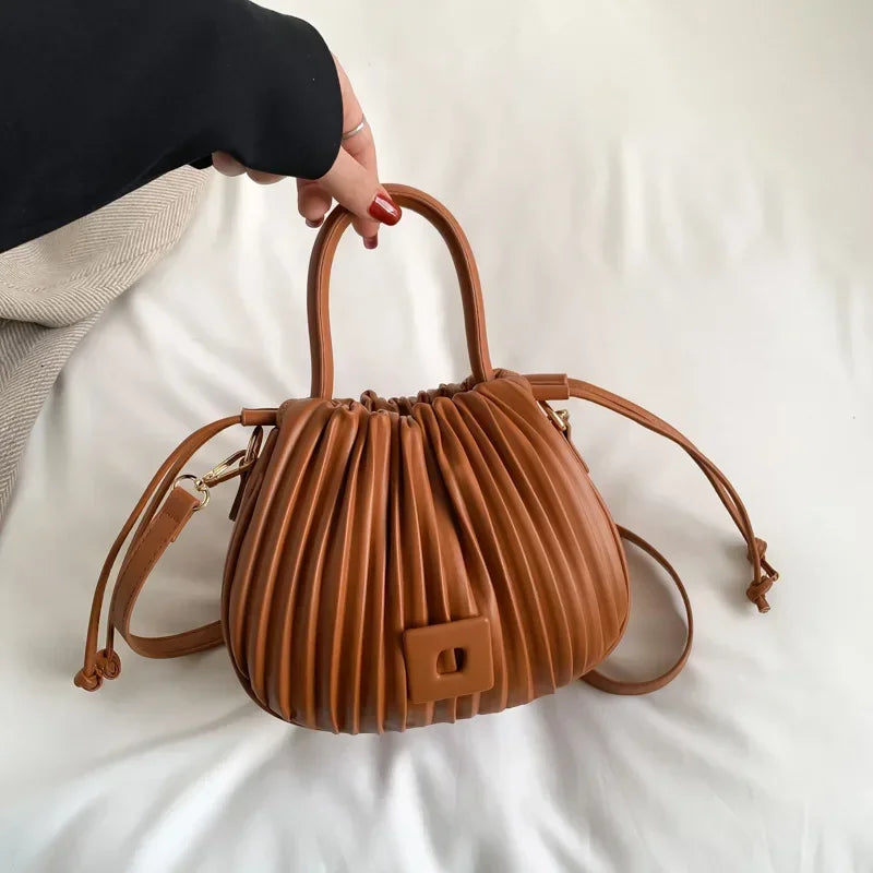Borsa a mano in pelle marrone con design plissettato, manici arrotondati e tracolla regolabile. Elegante accessorio moda donna.