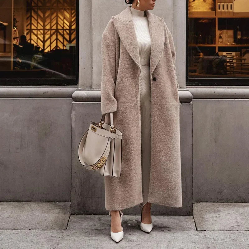 Cappotto lungo beige elegante donna, abbinato a borsa Fendi bianca e scarpe col tacco, moda autunno inverno, look sofisticato e chic.