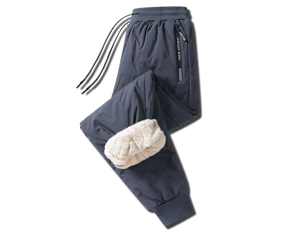 Pantaloni invernali da uomo, foderati in pile, colore grigio scuro, con tasche laterali e coulisse. Ideali per attività all'aperto e sport invernali.