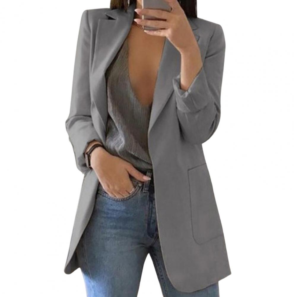 Giacca blazer donna grigia elegante, abbinata a top scollato e jeans. Moda femminile, abbigliamento casual chic, tendenze autunno 2023.
