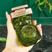 Barattolo di gel viso idratante verde con coperchio dorato, tenuto in mano. Cosmetico skincare, texture gel, confezione elegante.