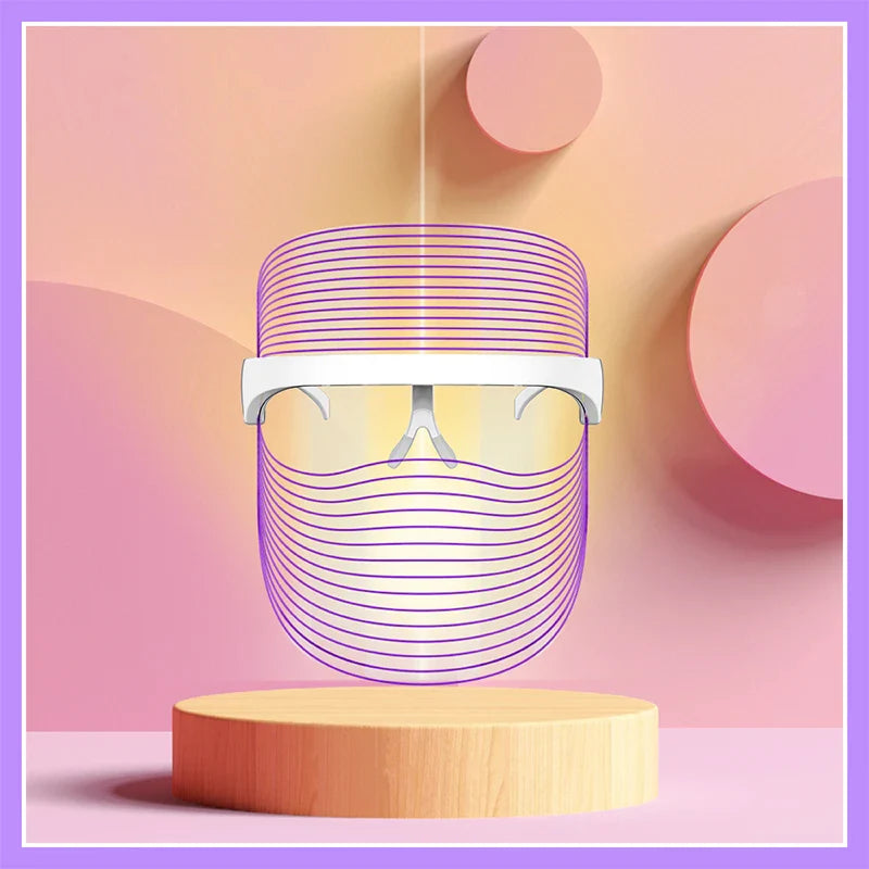 Occhiali futuristici con design a linee viola su sfondo astratto rosa e arancione, posizionati su un piedistallo di legno. Accessorio moda innovativo.