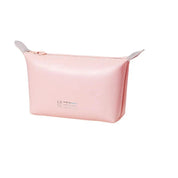 Astuccio cosmetico rosa in pelle sintetica con cerniera, design minimalista, ideale per trucchi e accessori da viaggio.