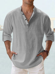 Camicia uomo lino grigia, maniche lunghe arrotolate, colletto alla coreana, abbottonatura frontale, stile casual estivo.
