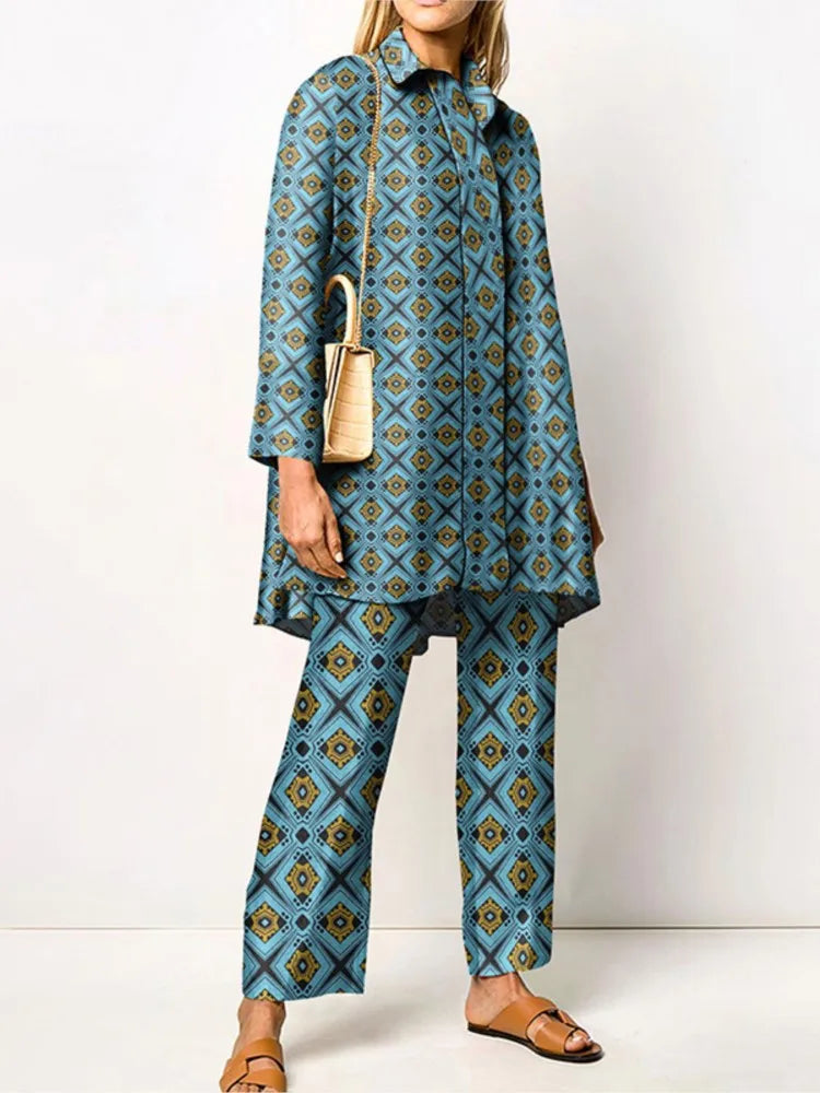 Donna in abito coordinato blu con motivo geometrico, borsa a tracolla beige e sandali marroni. Moda femminile elegante e moderna.