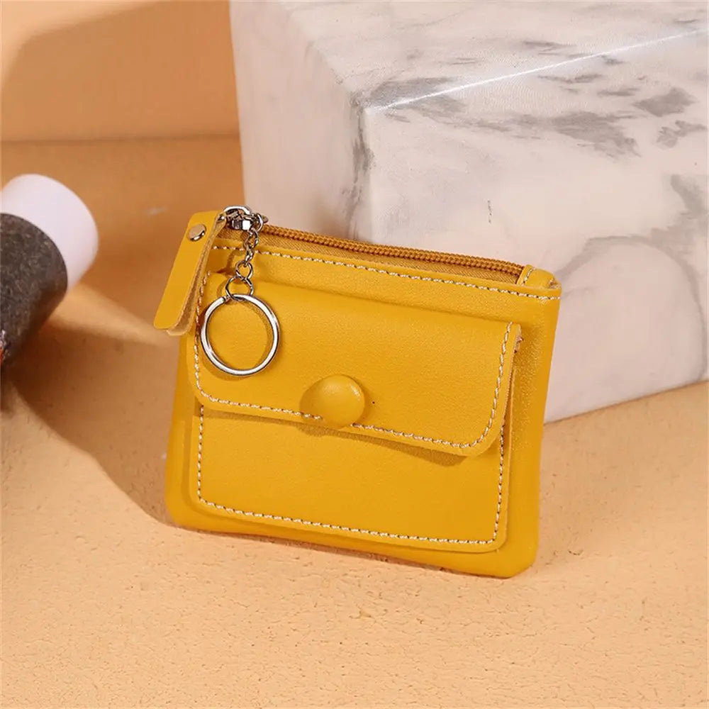 Portamonete giallo in pelle con cerniera e anello portachiavi, design compatto, elegante e funzionale, ideale per donna, accessorio moda.