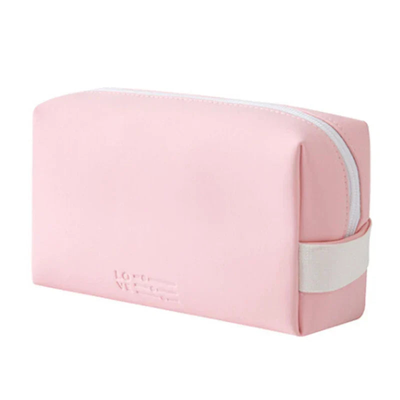 Astuccio da viaggio rosa in pelle sintetica con cerniera bianca, design minimalista, ideale per cosmetici e accessori.
