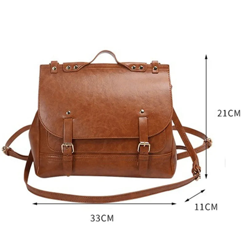 Borsa a tracolla in pelle marrone, dimensioni 33x21x11 cm, con fibbie decorative e manico superiore. Elegante e versatile per ogni occasione.