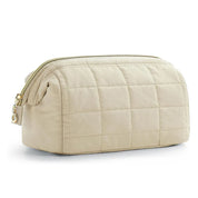 Borsa da toilette trapuntata beige con cerniera dorata, design elegante e spazioso. Accessorio da viaggio essenziale per organizzare cosmetici.