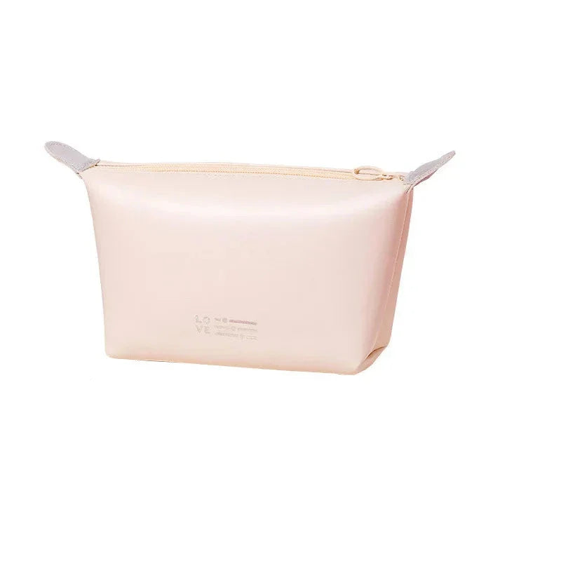 Astuccio cosmetico beige in silicone, design minimalista, chiusura con zip, ideale per organizzare trucchi e accessori da viaggio.