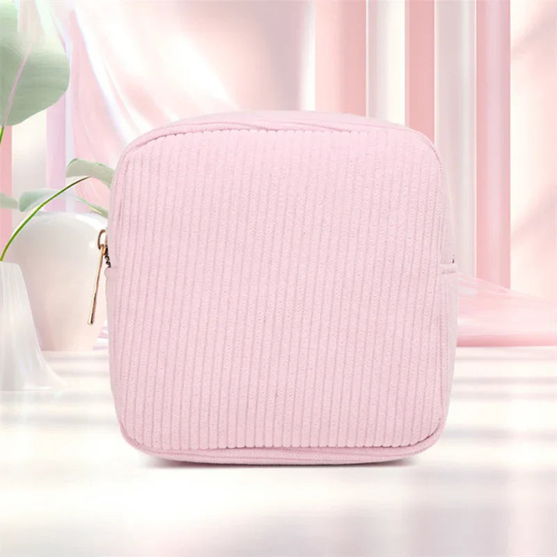 Borsa cosmetica rosa in tessuto a coste, design elegante e moderno, ideale per organizzare trucchi e accessori. Perfetta per viaggi e uso quotidiano.
