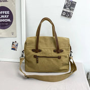 Borsa a tracolla in tela beige con manici in pelle marrone, tasche con zip, design casual. Ideale per lavoro e viaggi. Accessorio moda uomo e donna.