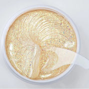 Maschera viso in gel dorato con glitter, idratante e illuminante, vista dall'alto. Trattamento skincare per pelle luminosa e radiosa.