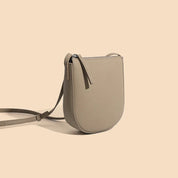 Borsa a tracolla in pelle beige, design minimalista, chiusura con zip, ideale per moda donna, accessorio elegante e versatile.