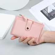 Portafoglio donna rosa in pelle sintetica, compatto e elegante, con chiusura a bottone. Ideale per carte e contanti. Accessorio moda femminile.